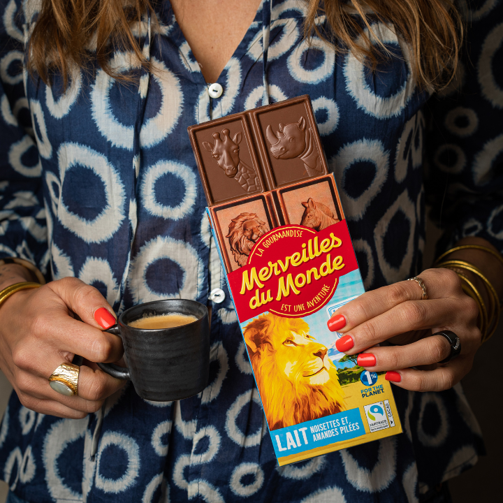 Mains de femme tenant une tablette de chocolat Merveilles du Monde et un café