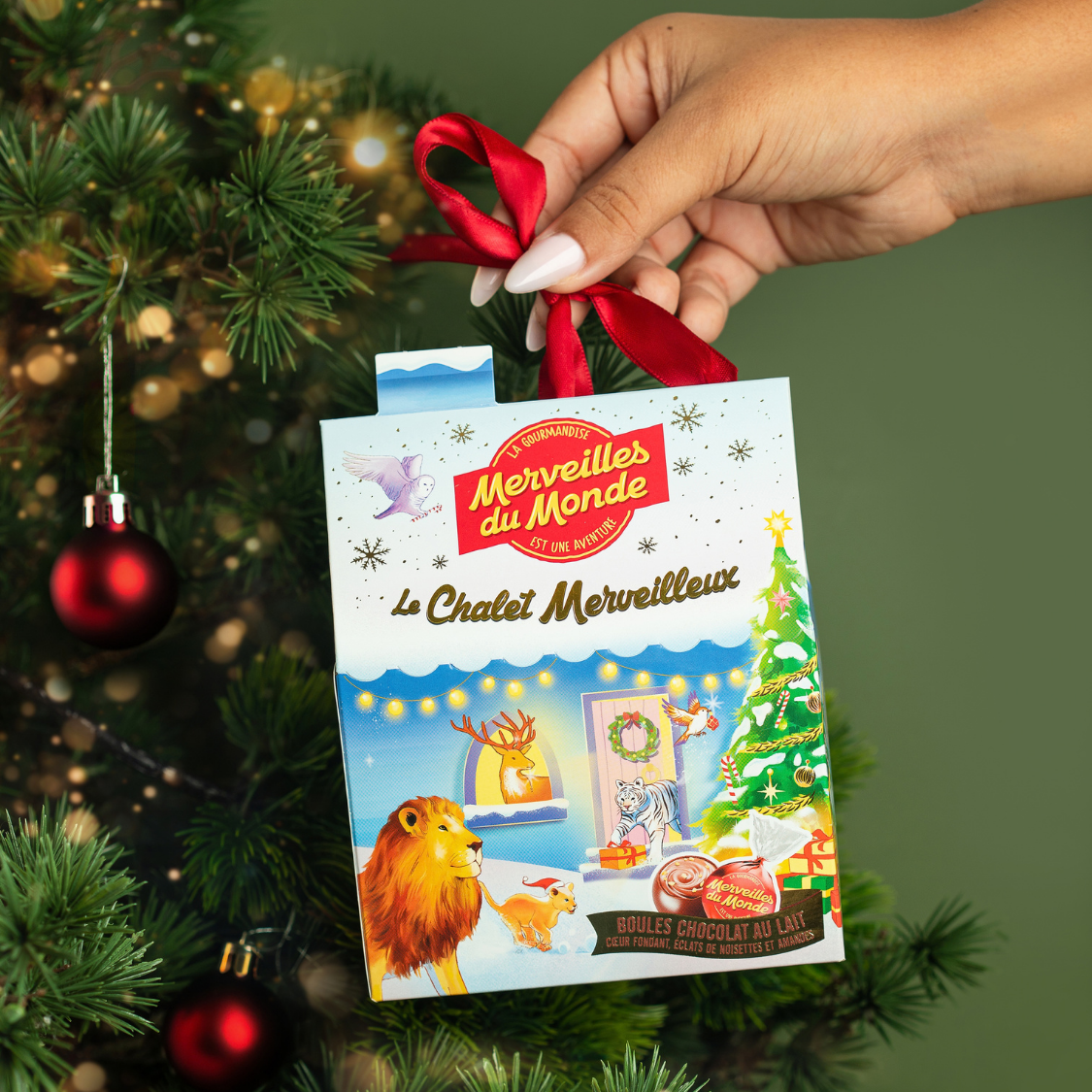 Entrez dans la magie des fêtes avec notre Chalet Merveilleux ! Sous son toit se cachent de délicieuses boules de chocolat au lait au cœur fondant, parsemé d’éclats croquants de noisettes et d’amandes. À accrocher dans le sapin pour une décoration féérique.