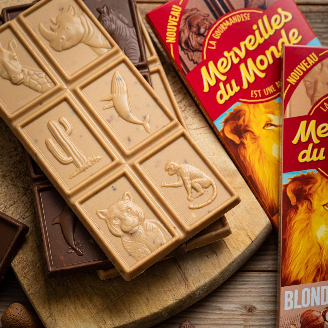 
                  
                    Tablettes de chocolat blond et chocolat au lait Merveilles du Monde avec inclusions de noisettes et d'amandes.
                  
                